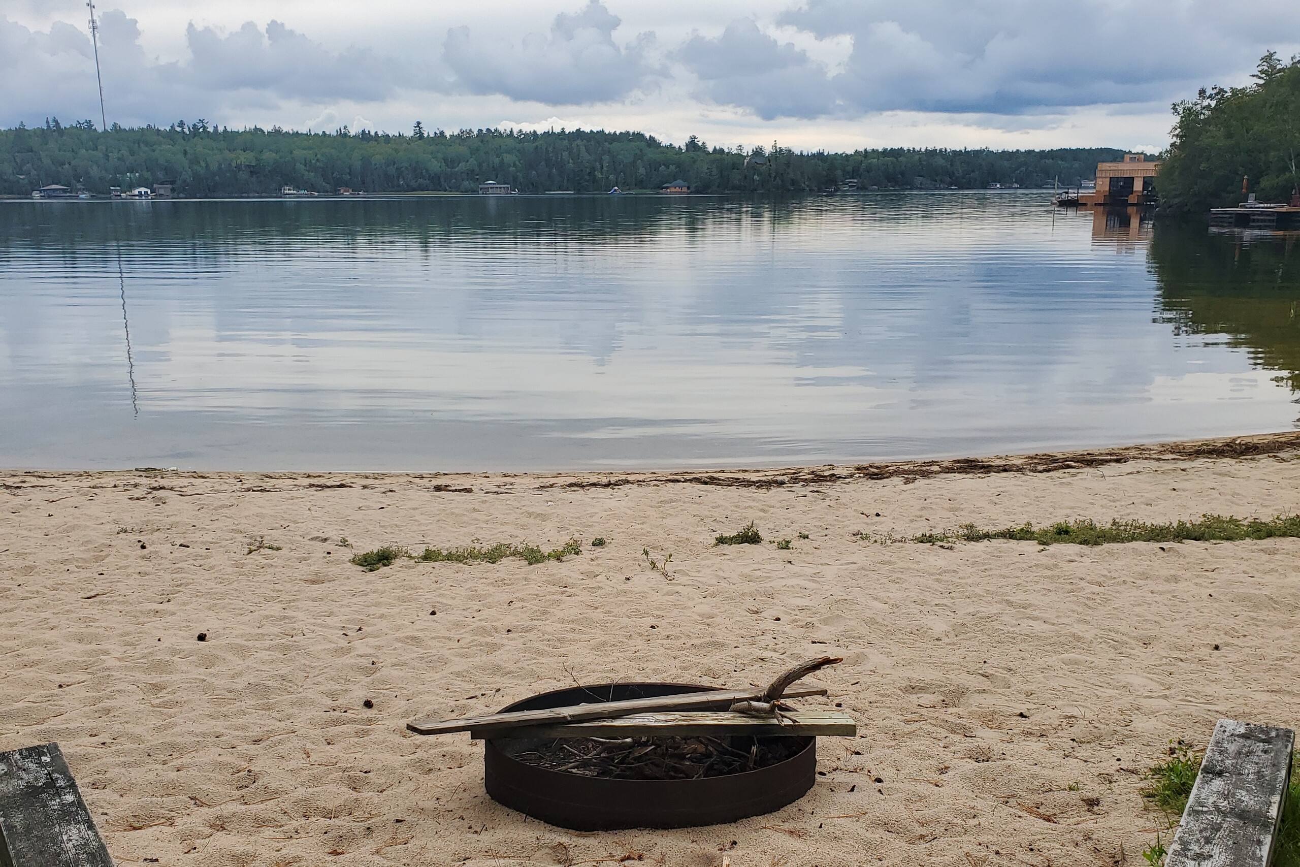 Private sandy beach with fire pit on the lake