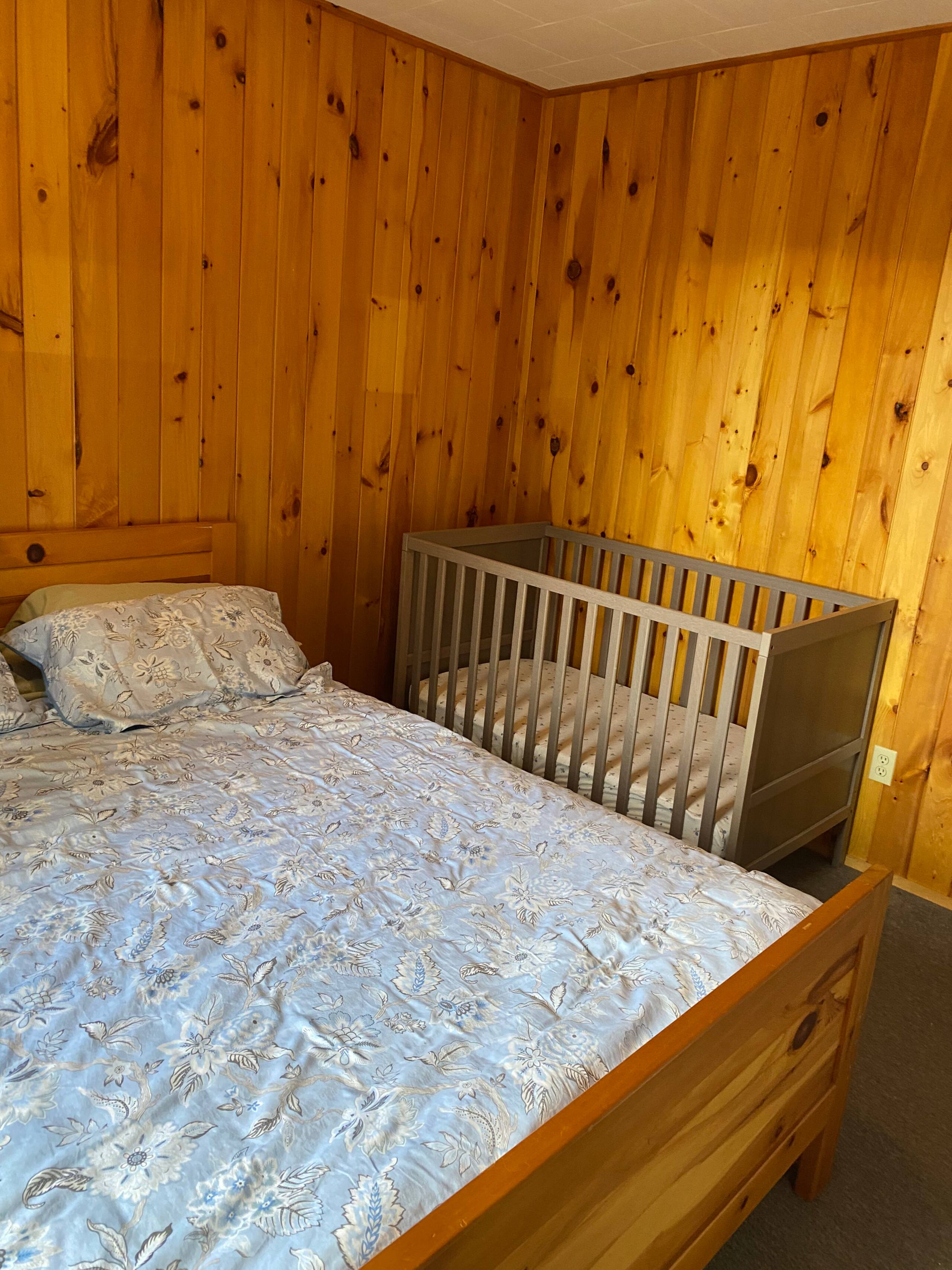Bedroom with queen bed and crib